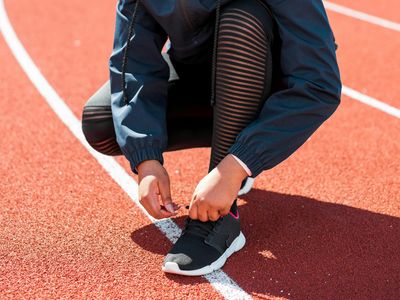 Close-up of a person tying their running shoes.